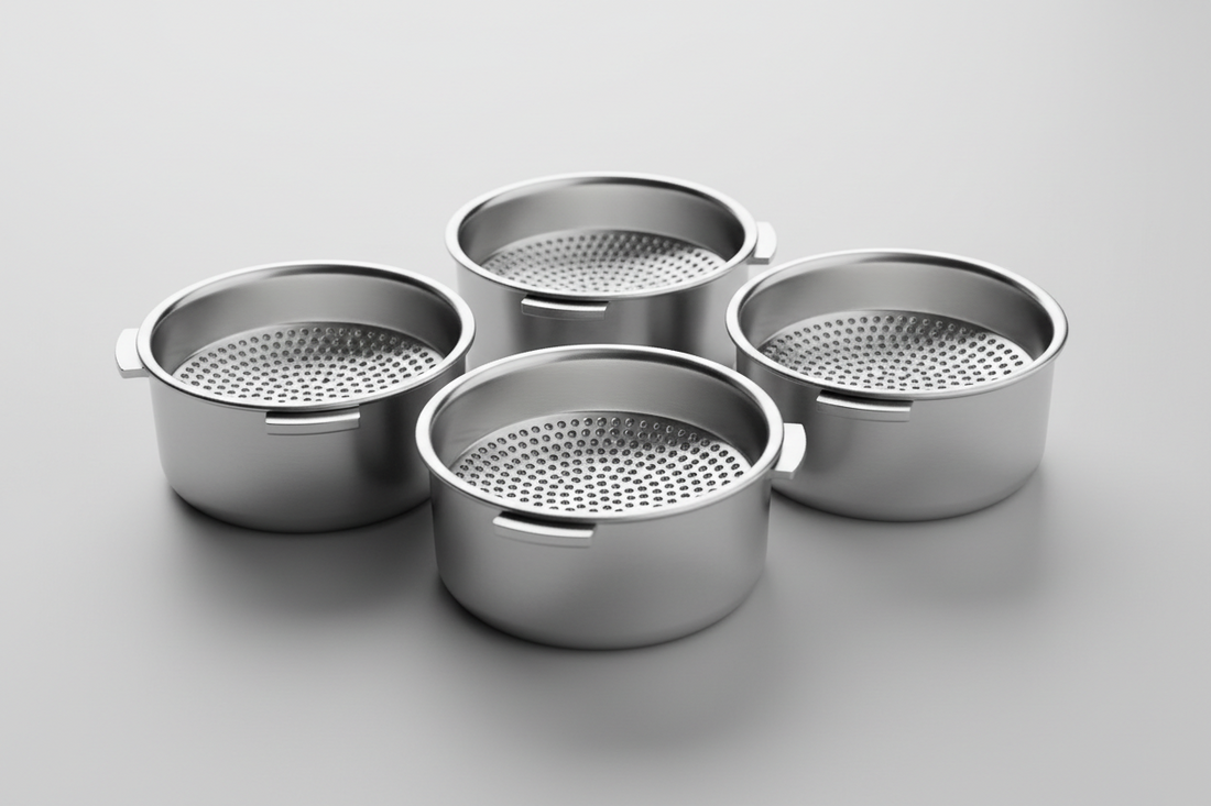 Close-up of precision espresso filter baskets showing laser-cut hole patterns and stainless steel construction for optimal coffee extraction