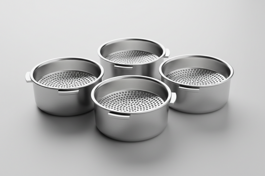 Close-up of precision espresso filter baskets showing laser-cut hole patterns and stainless steel construction for optimal coffee extraction